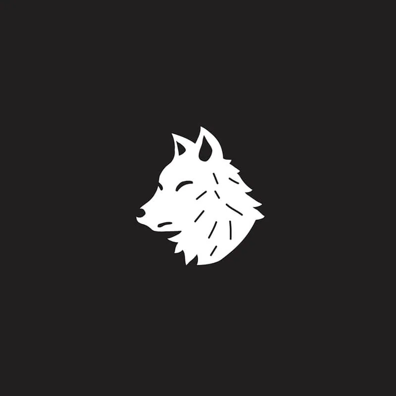 White wolf head mark in profile with a few short strokes for fur, on charcoal.